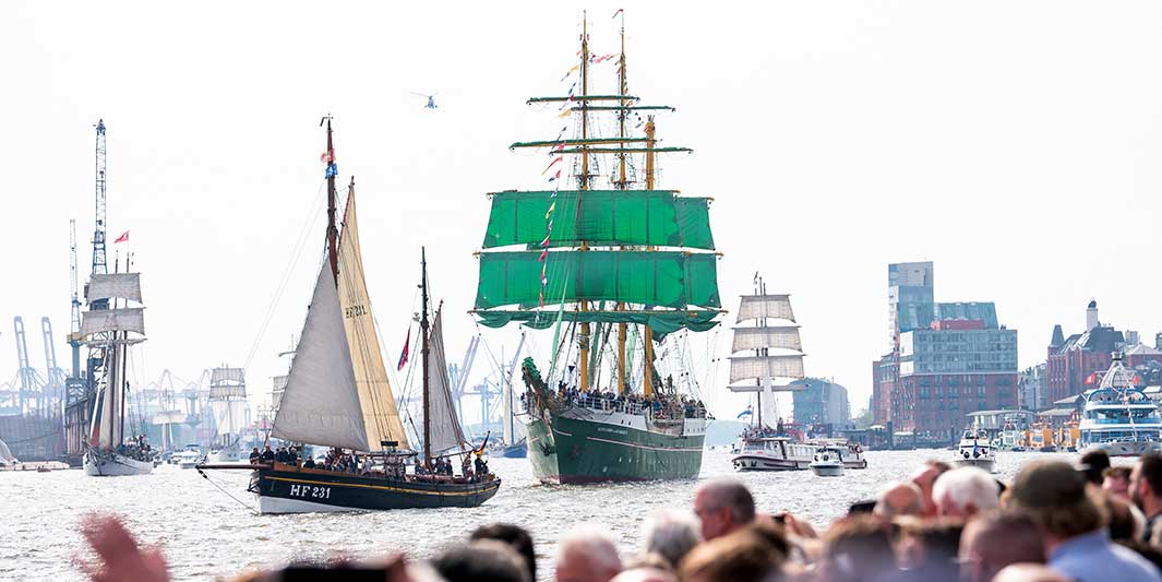 Zahlreiche Schiffe fahren während der Einlaufparade des 835. Hamburger Hafengeburtstags an den Landungsbrücken über die Elbe.