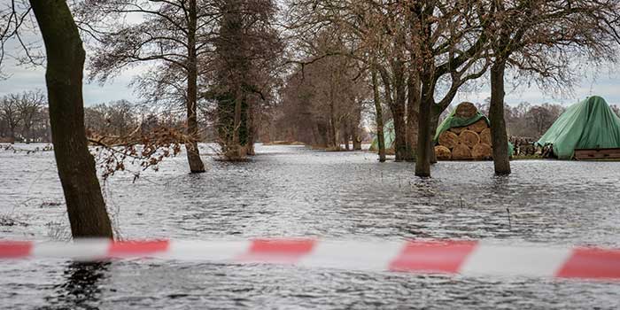 Hochwasser steht auf einem überfluteten Weg an der Landesgrenze zwischen Niedersachsen und Bremen in Lilienthal. Da durch das Hochwasser des Flusses ein Deich zu brechen drohte, mussten Hunderte Bewohner der dahinter liegenden Wohngebiete ihre Häuser verlassen.