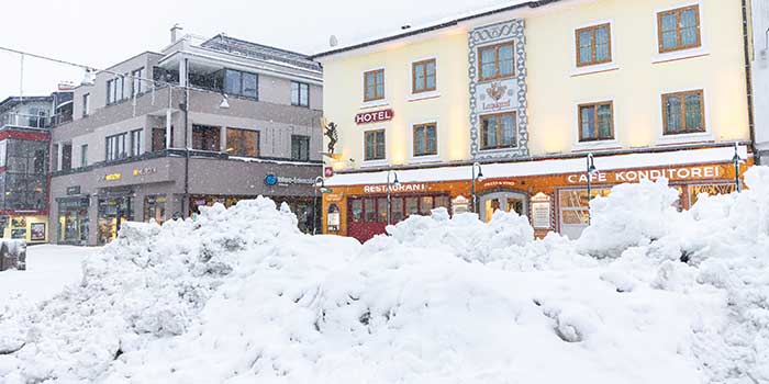 Im Bild ein großer Haufen Schnee, zusammengeschoben von Räumfahrzeugen, auf dem Hauptplatz von Schladming. 