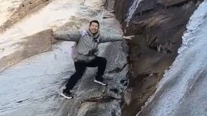 Reingefallen! Wanderer posiert ungeschickt an eisigem Wasserfall
